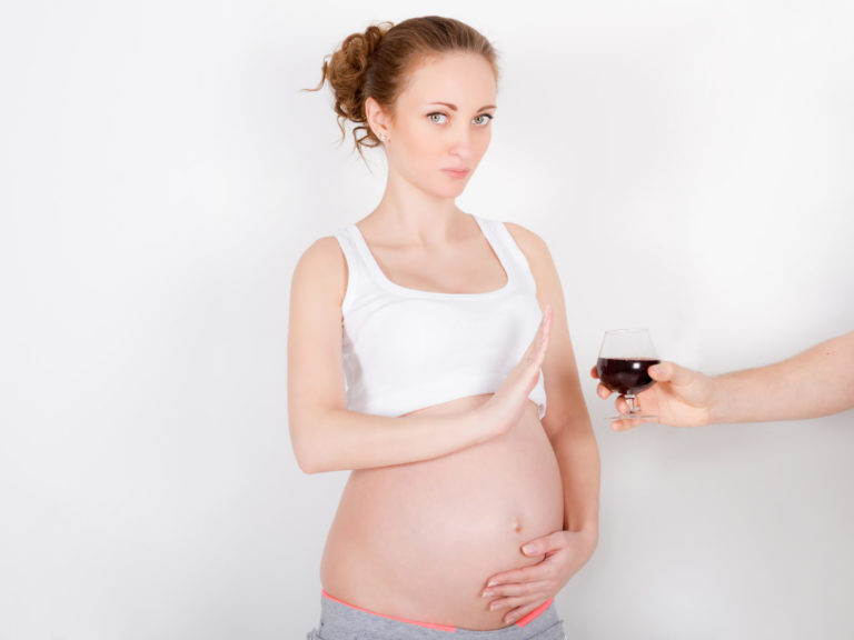 Beautiful young pregnant woman / teenager refuses to drink a wine