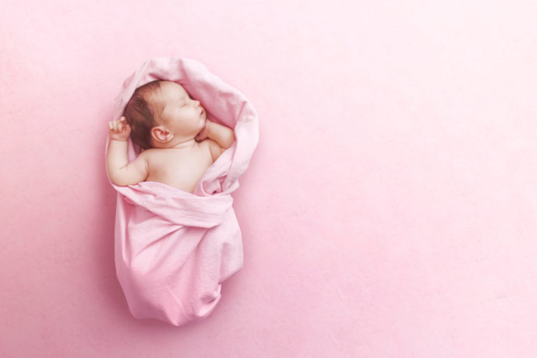 Newborn baby girl sleep on pink blanke