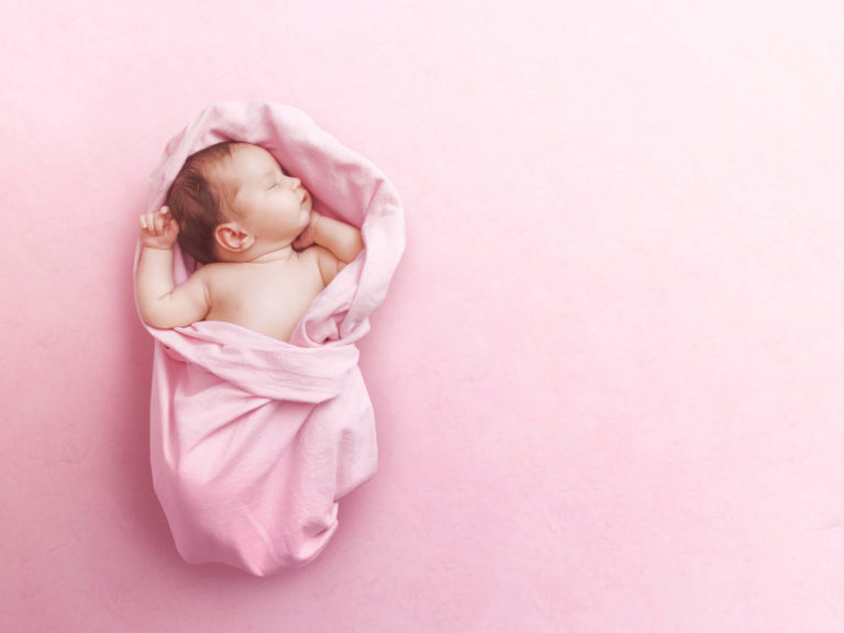 Newborn baby girl sleep on pink blanke