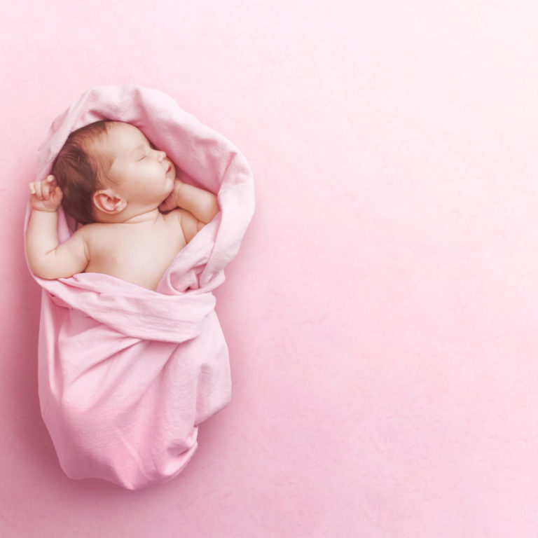 Newborn baby girl sleep on pink blanke