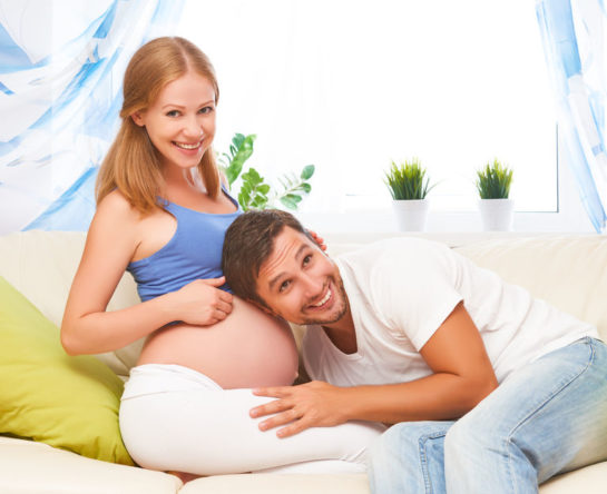 happy family in anticipation of the birth of baby. Pregnant woman and her husband at home
