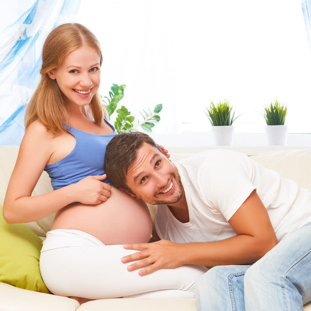 happy family in anticipation of the birth of baby. Pregnant woman and her husband at home